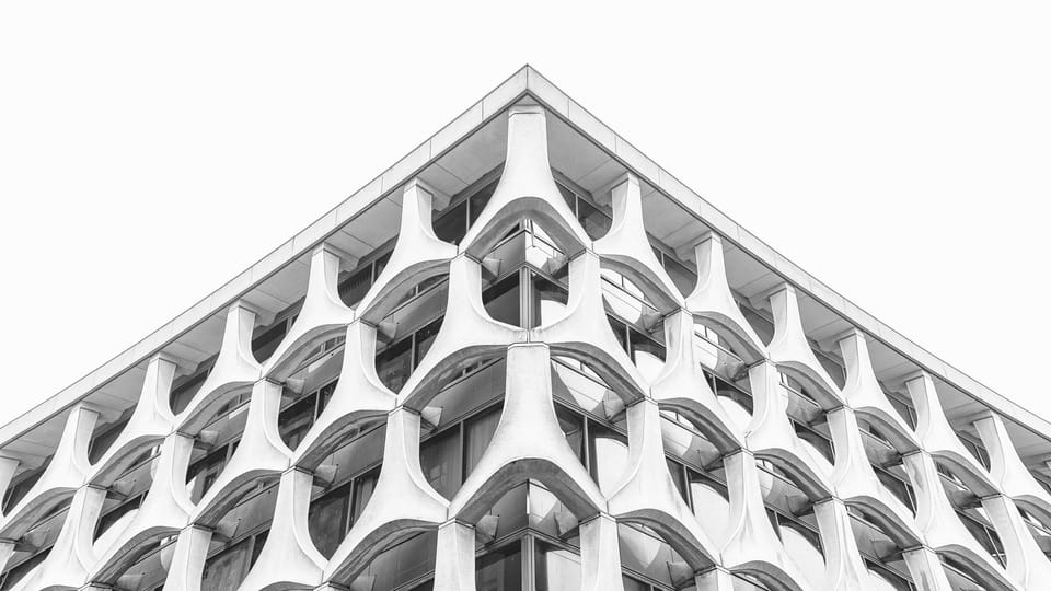 A black and white study of a honeycombed concrete building facade.